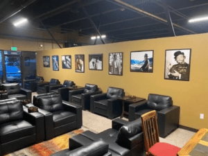 A modern room featuring sleek black leather chairs arranged around a television, creating a stylish and comfortable atmosphere.