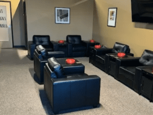 A modern room featuring sleek black leather chairs arranged around a television, creating a stylish and comfortable atmosphere.